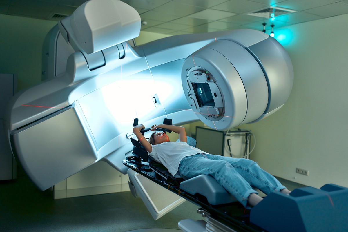 Imagem-radioterapia-r Paciente posicionada em máquina de radioterapia para tratamento de câncer.